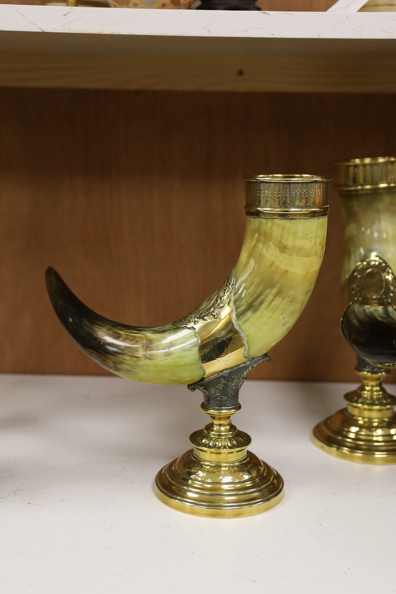 A pair of large decorative brass mounted horns, 33cm high. Condition - brass mounts dented and horns scratched in places